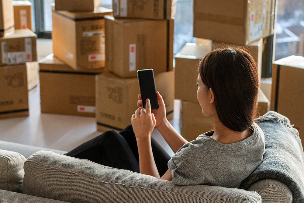 A Woman Is Talking On The Phone While Planning A Relocation